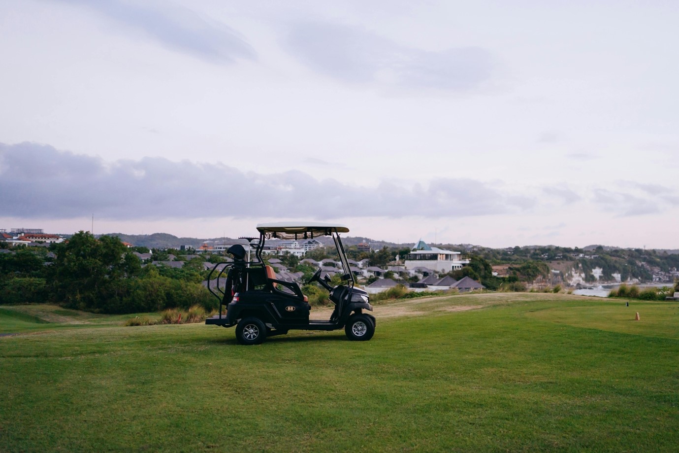 A black golf cart secluded on the course